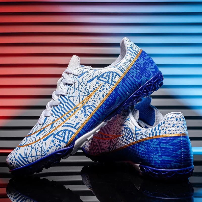 COMFORTH Men's white and blue graphic print synthetic turf soccer cleats with gold accents.