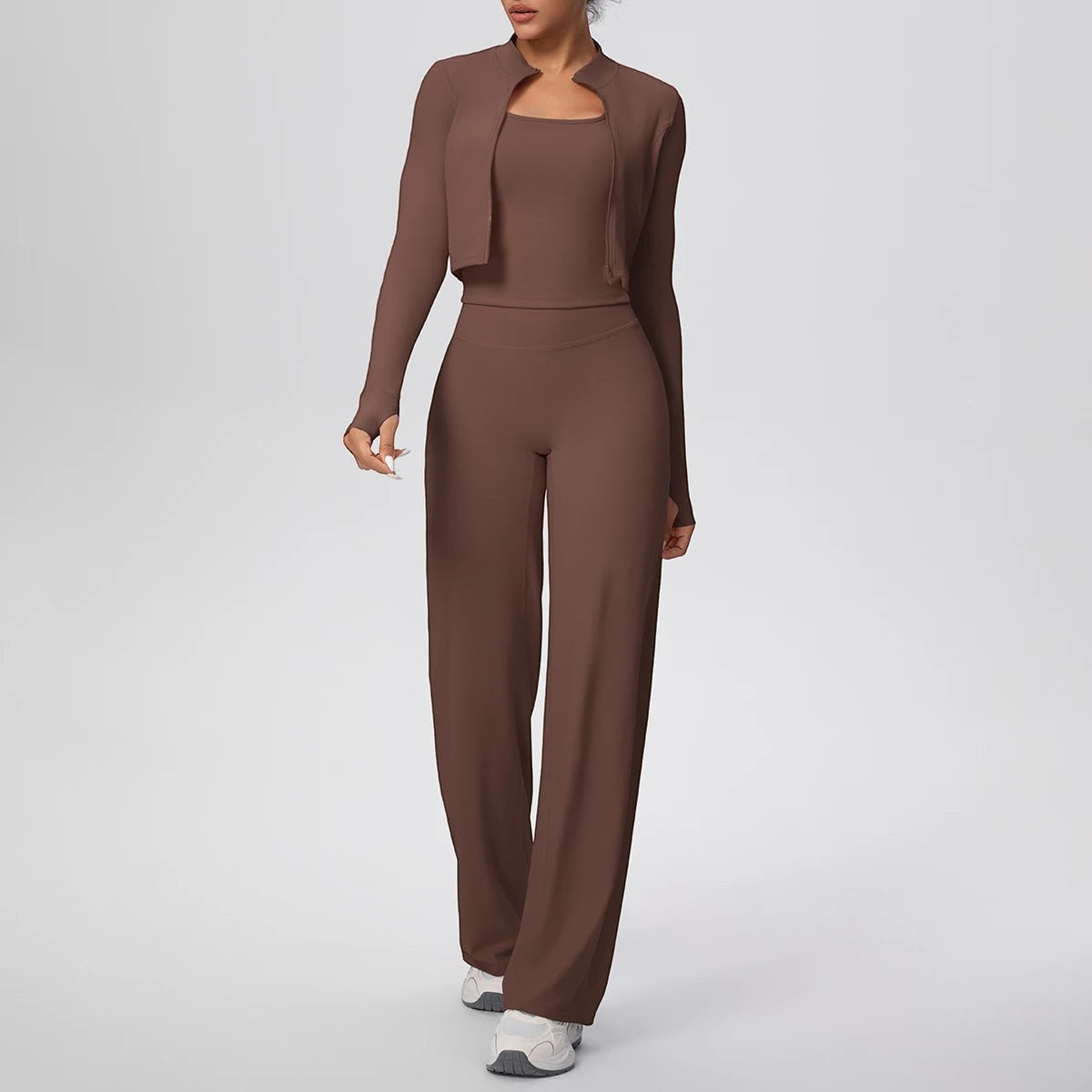 COMFORT Women's brown three-piece athletic set with cropped jacket, sports bra, and wide-leg pants.