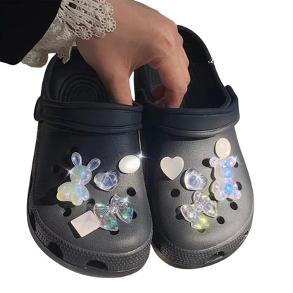 COMFORTH black clog shoes with iridescent bunny, heart, bow, and bear charms. Waterproof material.