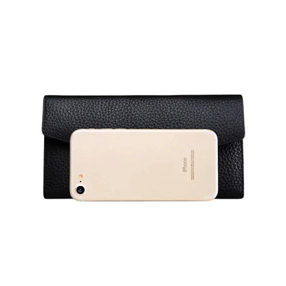 COMFORTH black textured leather envelope wallet with gold clasp, shown with iPhone for scale.