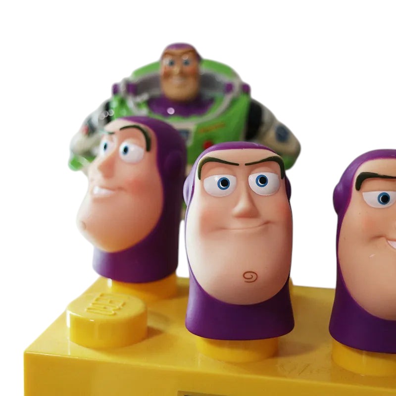 COMFORT Buzz Lightyear finger puppets with purple helmets and blue eyes on a yellow base, featuring a larger Buzz figure in the background.