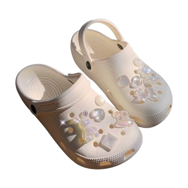 COMFORTH clogs in cream with iridescent bunny, heart, and bow charms. Lightweight, waterproof, and comfortable.