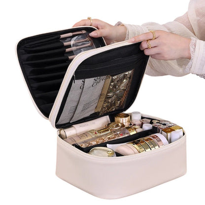 COMFORT cream PU leather travel makeup bag organizer with gold zipper and embroidered detail, featuring brush holders and mesh pockets.