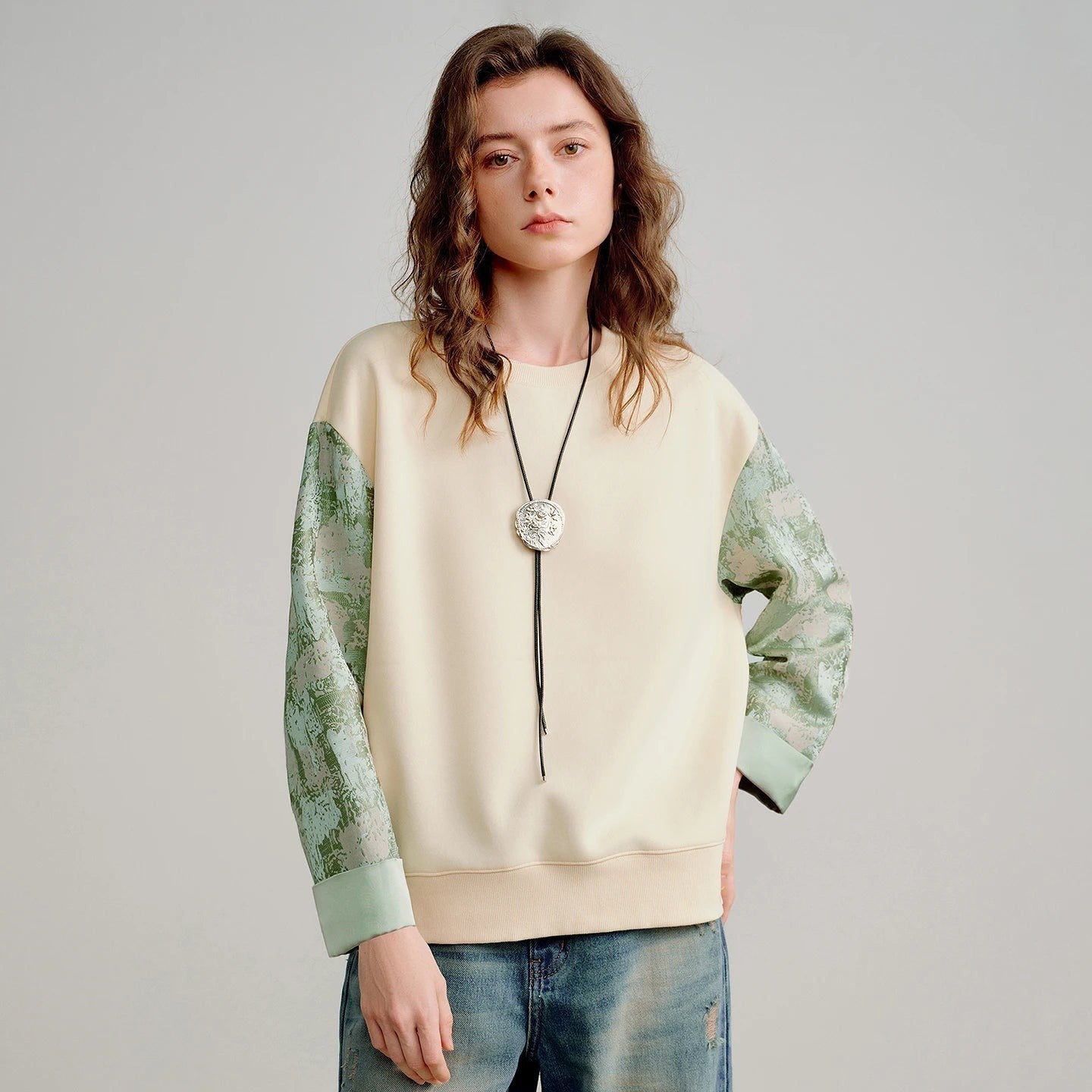 COMFORTH cream cotton blend crew neck sweatshirt with textured sage green contrasting sleeves and ribbed cuffs.