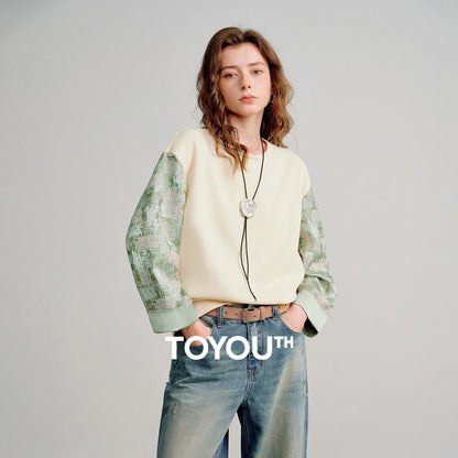 COMFORTH cream cotton blend crew neck sweatshirt with textured sage green contrasting sleeves and ribbed cuffs.