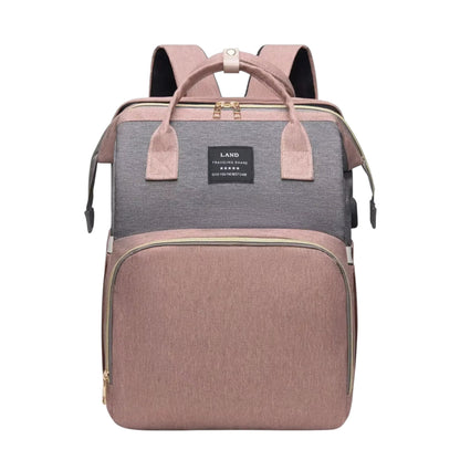 COMFORT Diaper Bag Backpack with Bassinet in dusty rose and grey, water-resistant fabric, multiple compartments, and expandable bassinet.