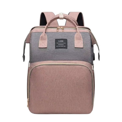 COMFORT Diaper Bag Backpack with Bassinet in dusty rose and grey, water-resistant fabric, multiple compartments, and expandable bassinet.