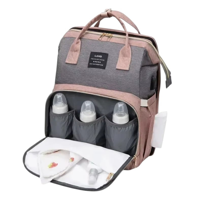 COMFORT Diaper Bag Backpack with Bassinet in grey and pink, featuring insulated bottle pockets and expandable bassinet.