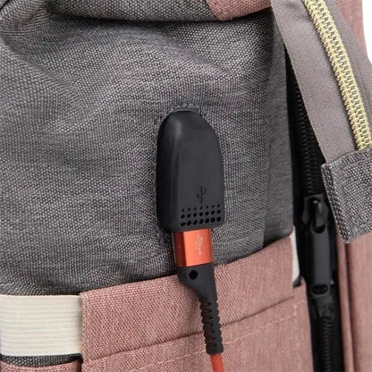 COMFORT diaper bag backpack in grey and pink fabric with external USB port and charging cable.
