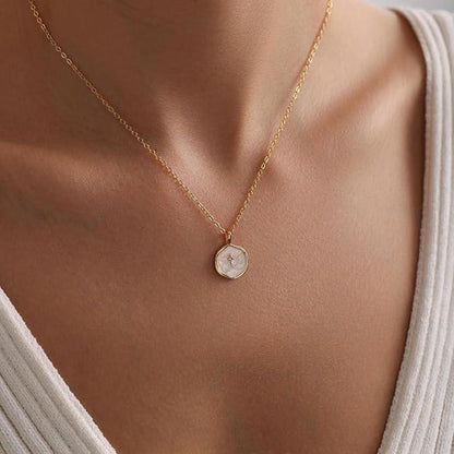 COMFORTH Gold plated necklace with a round, mother-of-pearl inlay pendant featuring a subtle cross design. Delicate chain.