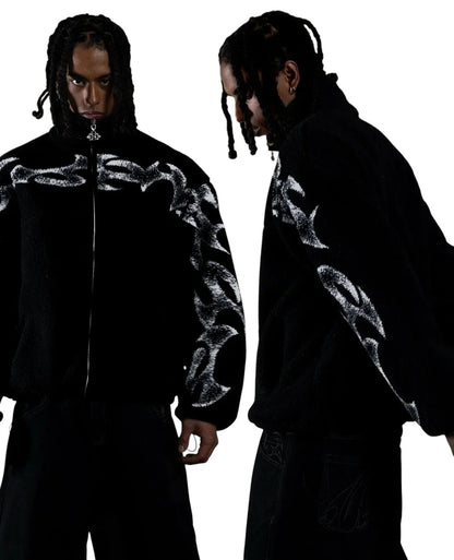 COMFORT black fleece jacket with white abstract flame graphic print, high collar, and full zip. Model wears relaxed fit.
