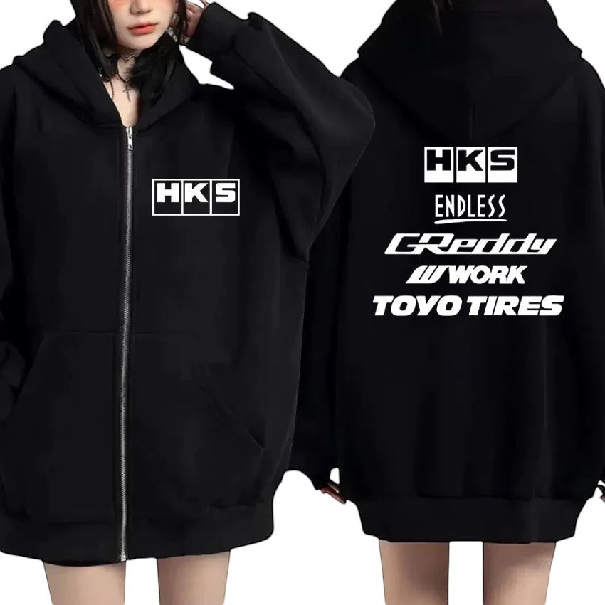 COMFORTHKS graphic zip-up hoodie in black with multiple brand logos on front and back. Features a full zip closure, hood, and front pockets.