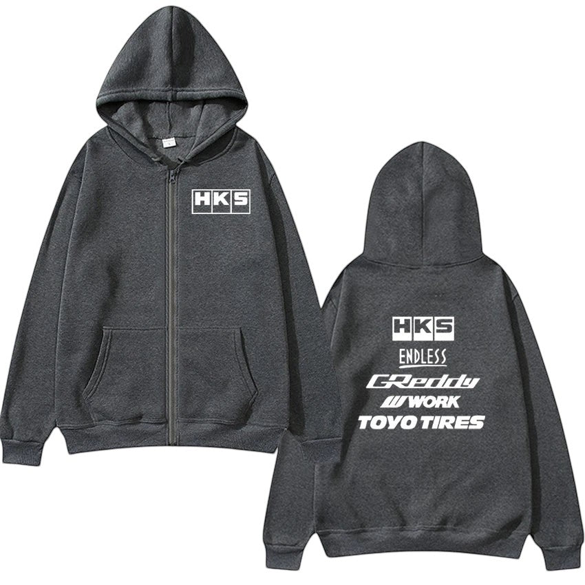 COMFORTHKS graphic zip-up hoodie in charcoal grey with multiple brand logos on front and back. Features a full zip, hood, and front pockets.