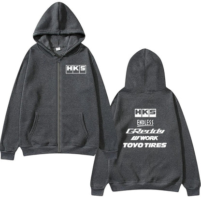 COMFORTHKS graphic zip-up hoodie in charcoal grey with multiple brand logos on front and back. Features a full zip, hood, and front pockets.