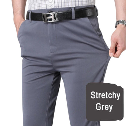 COMFORTH Men's grey stretch dress pants with a tailored fit and flat front. Features a black belt and watch.
