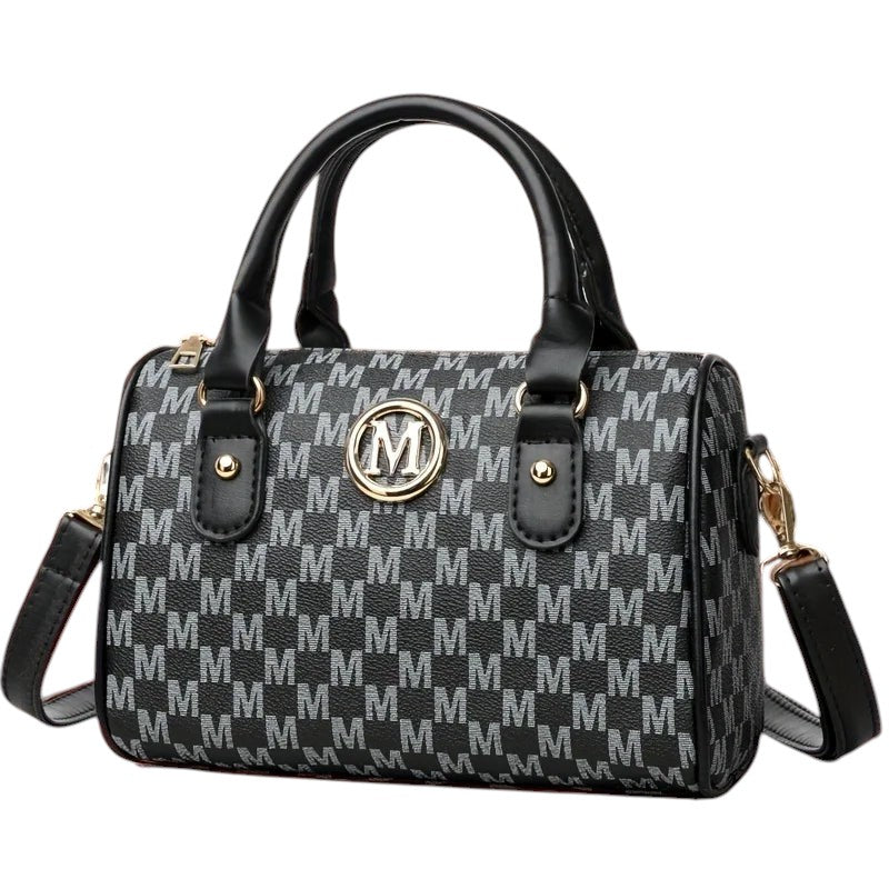 COMFORTHere Monogram Barrel Handbag with shoulder strap, black and grey monogram print, gold emblem, top handles, and detachable strap.