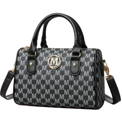 COMFORTHere Monogram Barrel Handbag with shoulder strap, black and grey monogram print, gold emblem, top handles, and detachable strap.
