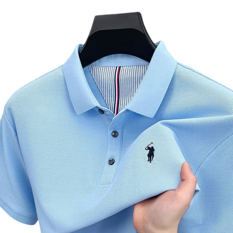 COMFORTH Men's light blue pique knit short sleeve polo shirt with embroidered logo and striped inner collar.