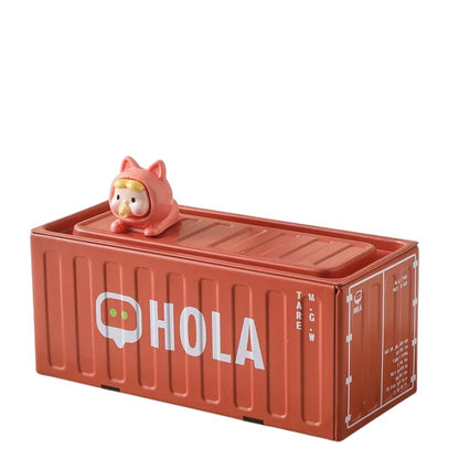 COMFORTH metal pen holder shaped like a red shipping container with "HOLA" text and a cute baby figure on top.