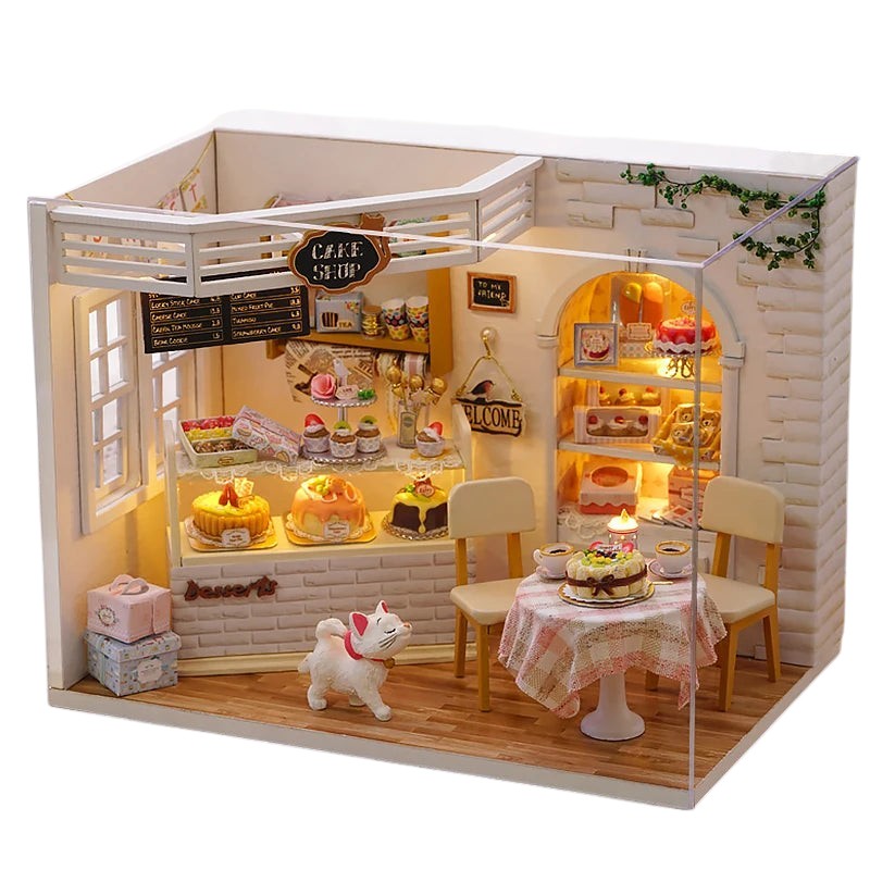 COMFORTH miniature dollhouse building kit featuring a charming bakery scene with cakes, pastries, and a white cat figurine.