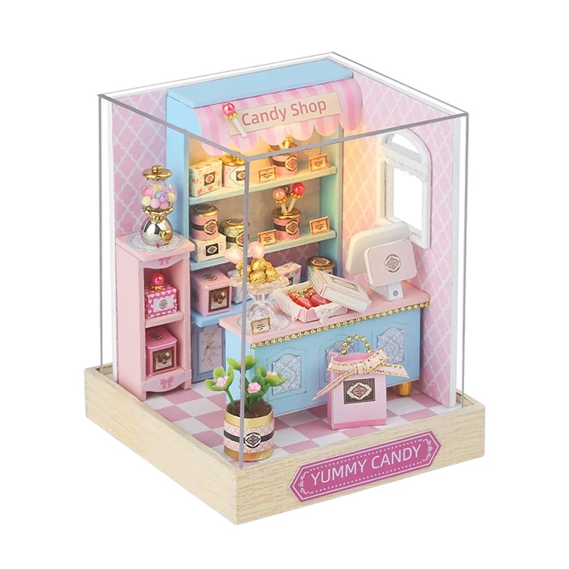 COMFORTH miniature candy shop dollhouse building kit with shelves, counter, gumball machine, and decorative candy boxes.