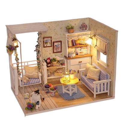 COMFORTH miniature dollhouse kit with a porch swing, sofa, table, and cat figurine. Features floral wallpaper and wood floors.