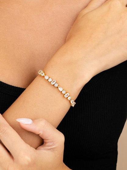 COMFORTH Mixed shape tennis bracelet with clear crystal accents on a gold-tone finish. Features round, oval, and pear cuts.