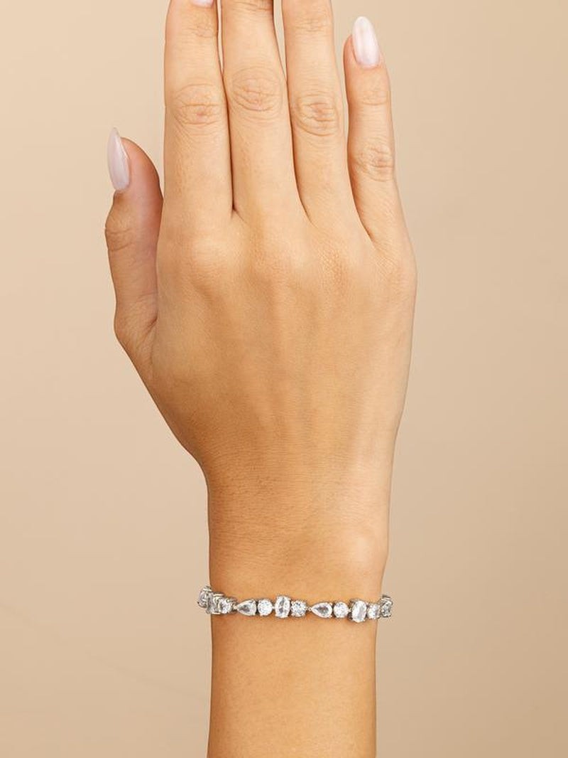 COMFORTH mixed shape tennis bracelet with crystal accents in round, oval, and pear cuts on a gold-tone finish.