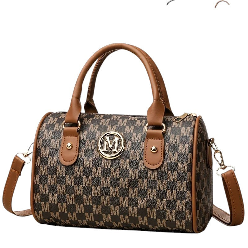 COMFORTH Monogram barrel handbag in brown with tan trim and gold hardware. Features top handles and a detachable shoulder strap.