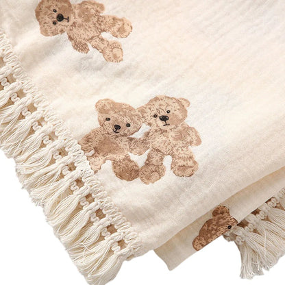 COMFORTH Muslin blanket with fringe and all-over teddy bear print in neutral tones. Soft, breathable fabric.