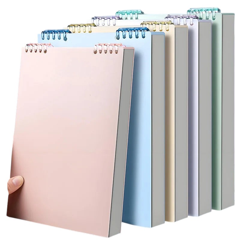 COMFORT spiral bound notebooks in pastel blush pink, sky blue, yellow, lavender, grey, and mint green. Durable covers, 360-degree binding.