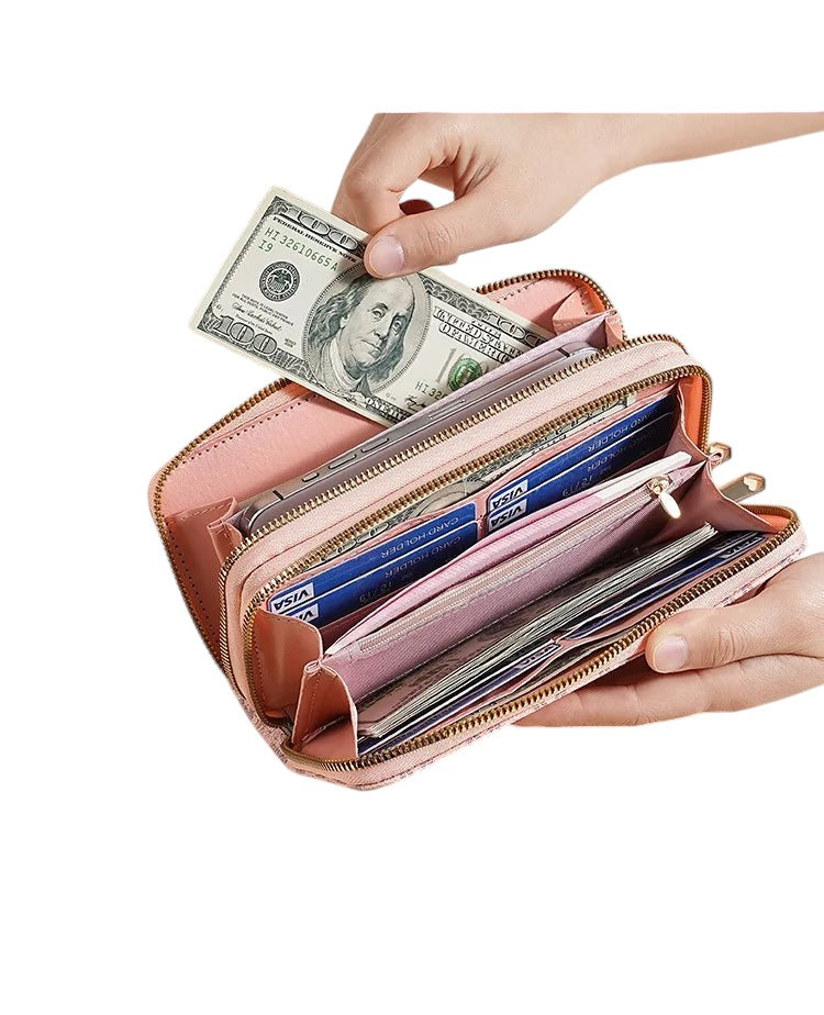 COMFORTH Double Zip Wristlet Wallet in pink faux leather with multiple card slots and gold-tone hardware. A hand inserts cash.
