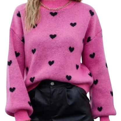 COMFORTHot pink knit sweater with black heart pattern, long sleeves, crew neck, and ribbed cuffs and hem.