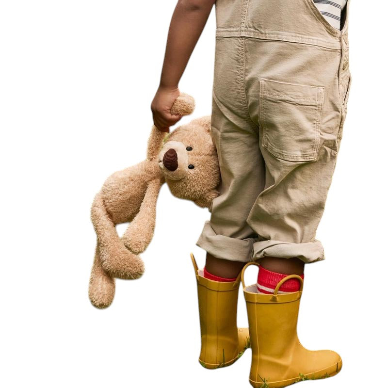 COMFORT plush teddy bear toy in beige, with embroidered eyes and brown nose, held by a child.