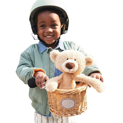 COMFORT plush teddy bear toy in a woven basket on a child's bike. Beige bear with brown nose.