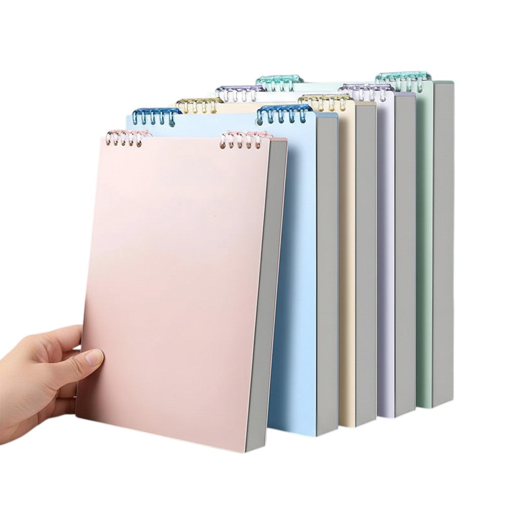 COMFORT spiral bound notebooks in pastel blush pink, sky blue, yellow, lavender, grey, and mint green. Durable covers, spiral binding.