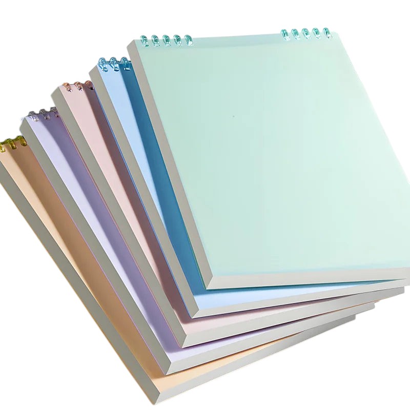 COMFORT spiral bound notebooks in pastel blush pink, sky blue, gentle yellow, lavender, light grey, and mint green. Durable covers, spiral binding.