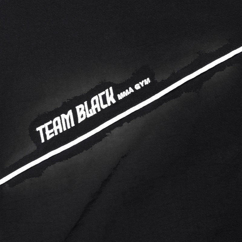 COMFORTH black track jacket with white piping and "TEAM BLACK MMA GYM" graphic. Lightweight material, full-zip, stand-up collar.