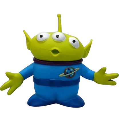 COMFORTH Toy Story Alien figure, green head, three eyes, blue uniform with Pizza Planet logo, articulated arms and head.