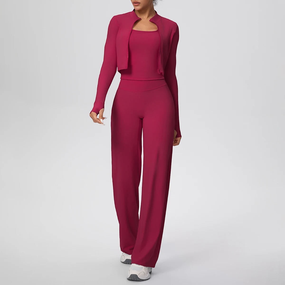COMFORT Women's three-piece athletic set in deep pink, featuring a cropped jacket, sports bra, and wide-leg pants with thumbholes.