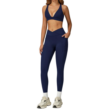 COMFORTH women's navy blue athletic two-piece set with V-neck sports bra and high-waisted flare leggings with pockets.