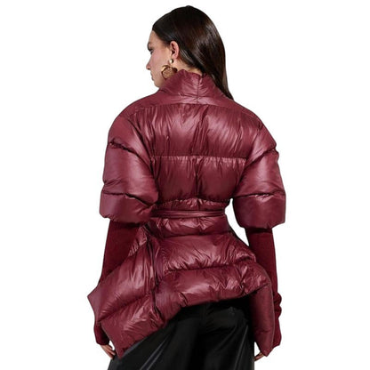 COMFORT Women's burgundy puffer jacket with belt, voluminous sleeves, and high collar. Model wears it over a burgundy sweater and black pants.