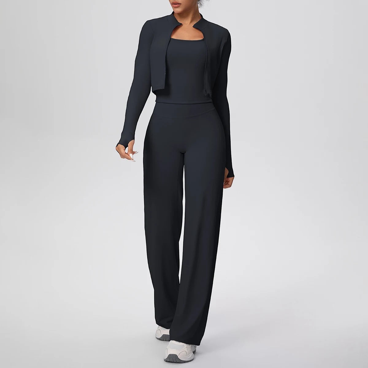 COMFORT Women's black three-piece athletic set with cropped jacket, sports bra, and wide-leg pants.