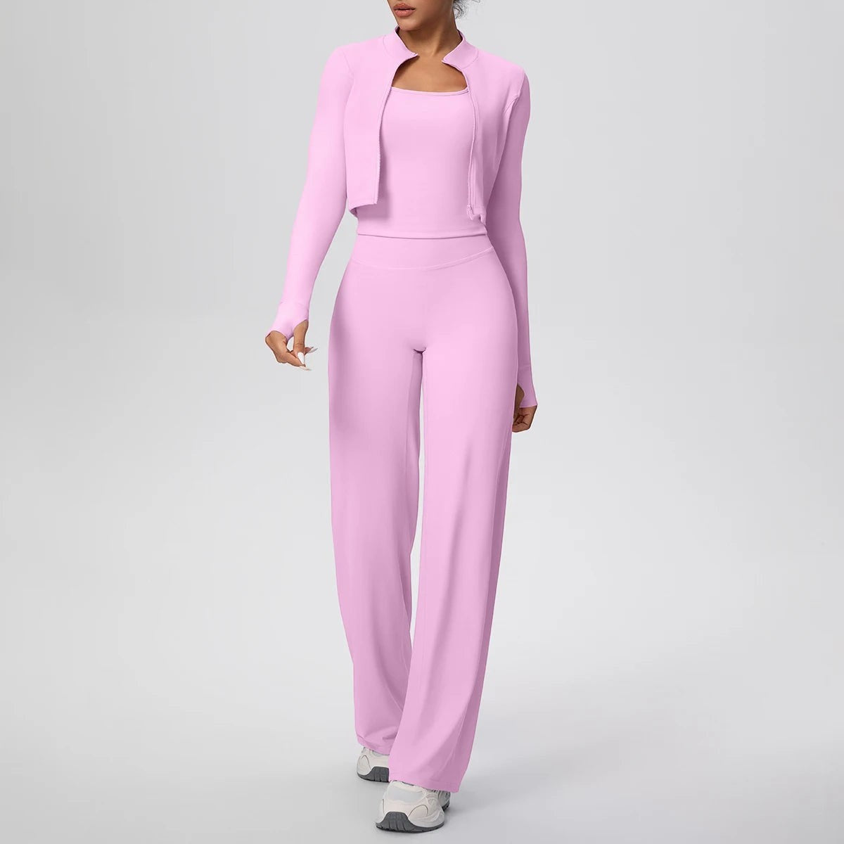 COMFORT Women's three-piece athletic set in light pink, featuring a cropped jacket, scoop-neck bra, and wide-leg pants.