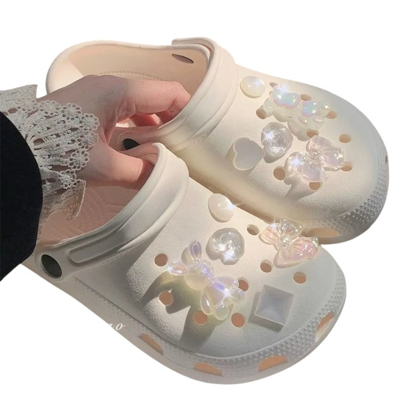 COMFORTH clogs in cream with iridescent bunny, heart, and bow charms. Lightweight, waterproof, and comfortable.