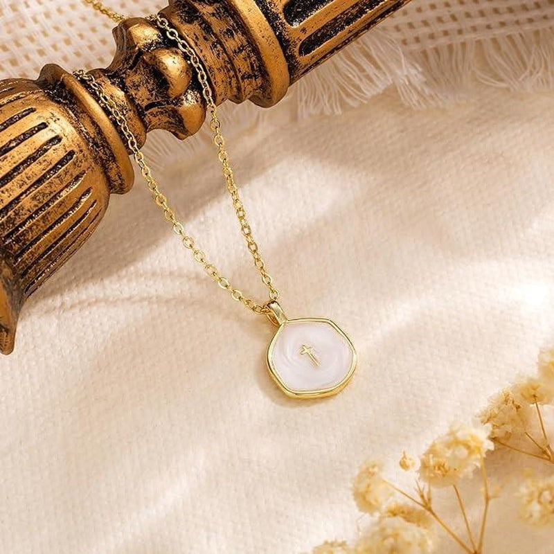 COMFORTH gold plated necklace with a white inlay pendant featuring a subtle cross design. Delicate chain, modern aesthetic.