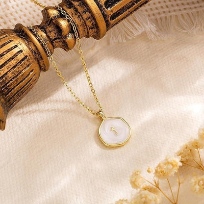 COMFORTH gold plated necklace with a white inlay pendant featuring a subtle cross design. Delicate chain, modern aesthetic.