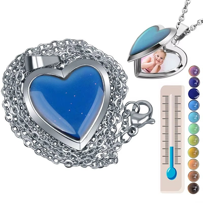COMFORTH silver-tone heart locket necklace with a thermochromic stone that changes color and a space for a photo. Includes a thermometer graphic showing color changes.