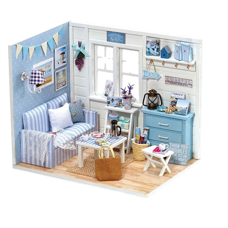 COMFORTH Miniature dollhouse kit with a coastal living room theme, featuring a blue striped sofa, white table, and beach-themed decor.
