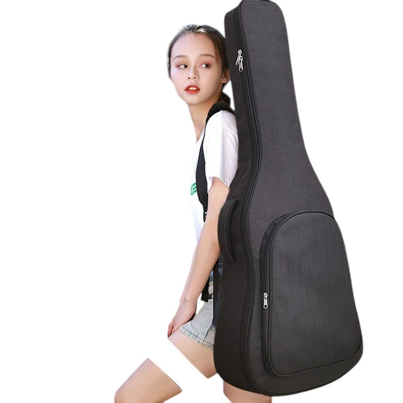 COMFORTH padded black guitar gig bag with carrying handle and front pocket, worn by a young woman.